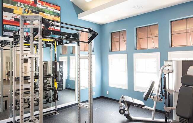 A gym with a blue wall and a variety of equipment.