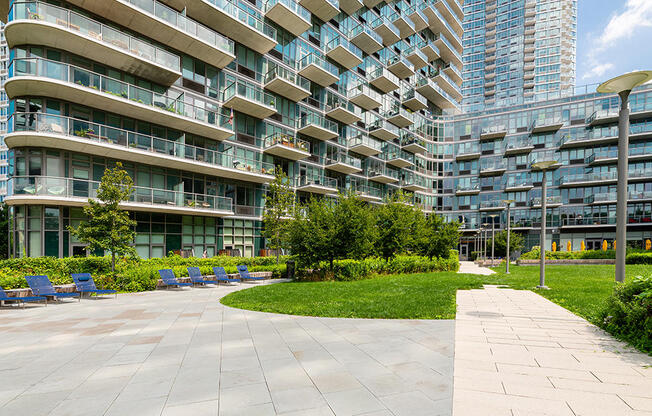 Large private outdoor amenity space and garden with sun chairs in Long Island City. 