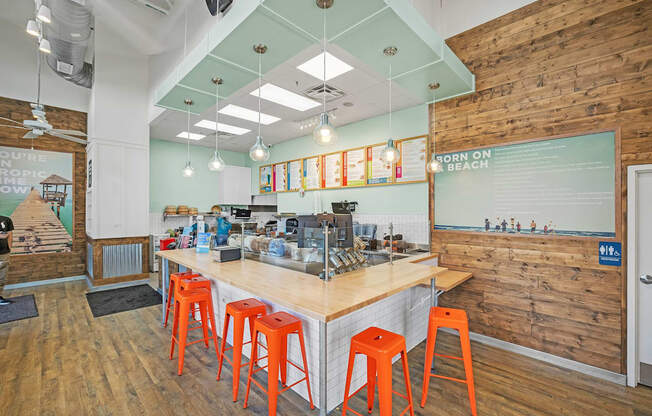 A bar with orange stools and a wooden wall.