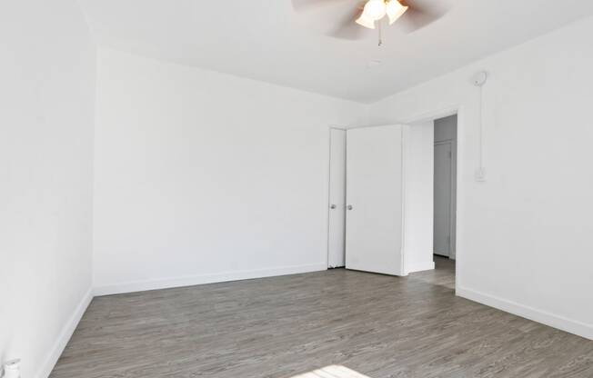 an empty living room with white walls and a wood floor