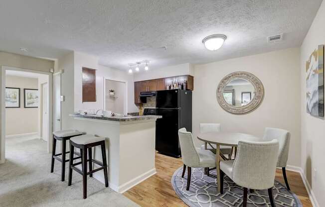 A kitchen area with a bar and a dining table.