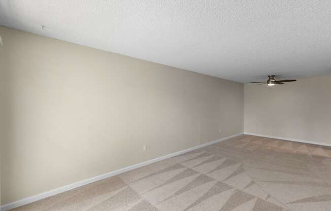 A Spacious Living room with a ceiling fan and tan carpet at Park Edmonds Apartment Homes, Edmonds, Washington