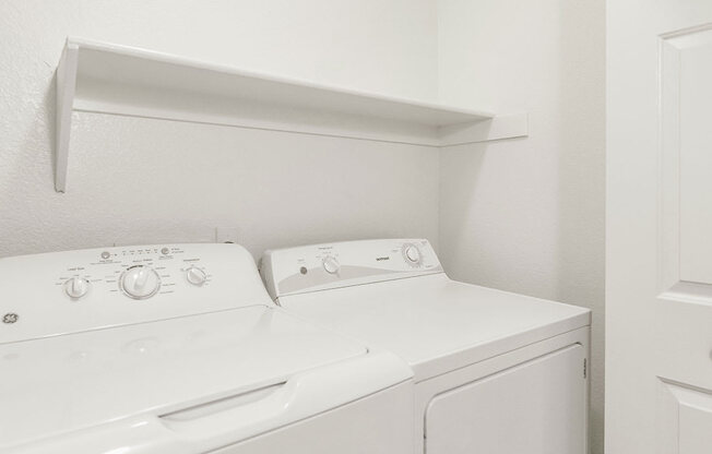 an empty laundry room with a washer and dryer