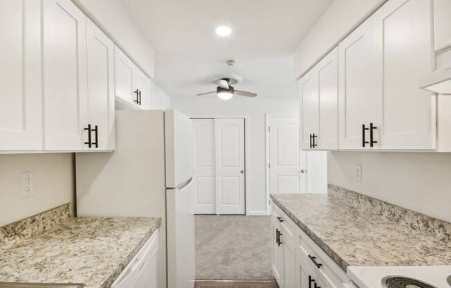 view of kitchen with white cabinets and granite counter tops and white appliances