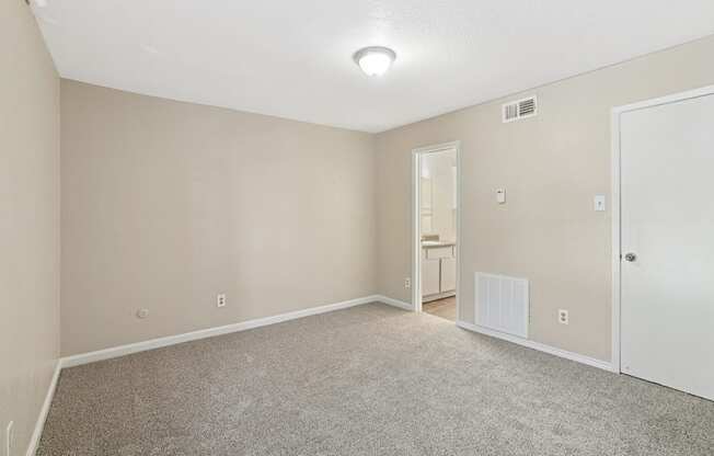 A room with a carpeted floor and a white door.