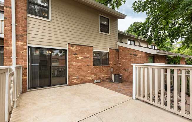 A house with a brown brick wall and a white fence.