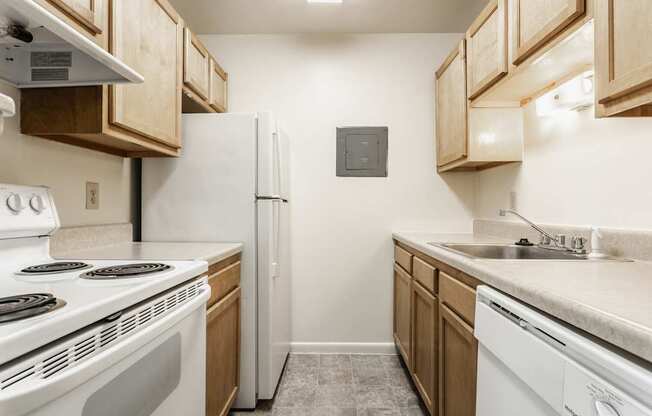 A kitchen with white appliances and wooden cabinets.