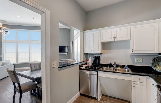 a kitchen with white cabinets and a sink and a window