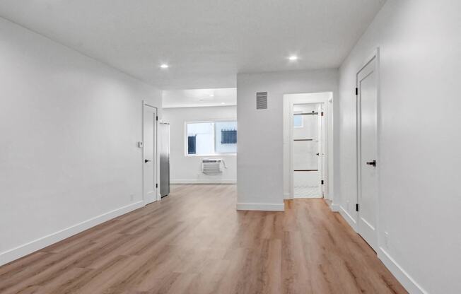 a living room with white walls and wood floors