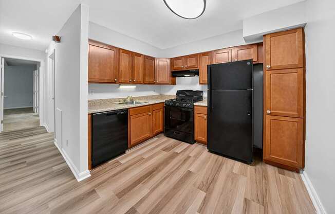 A kitchen with wooden cabinets and black appliances.