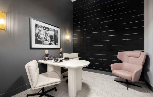 a small office with a pink chair and a white desk