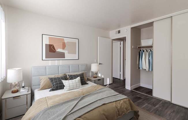 A bedroom with a large bed and a painting on the wall.