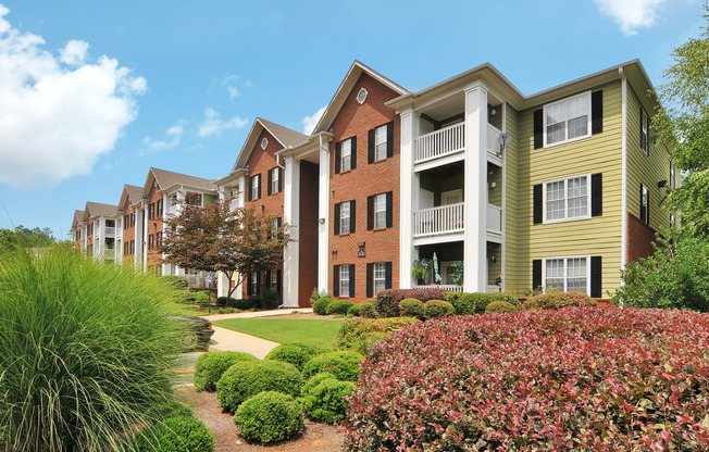 Exterior of apartment with a grass area and flower bed by the building