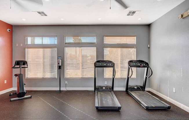 A room with treadmills and a fan.