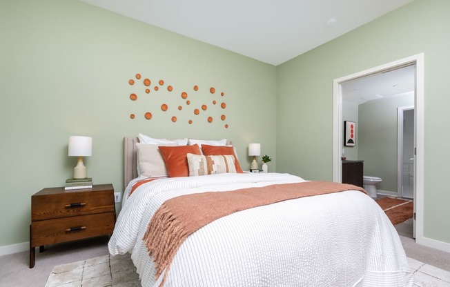 A bedroom with a bed, nightstand, and lamp.