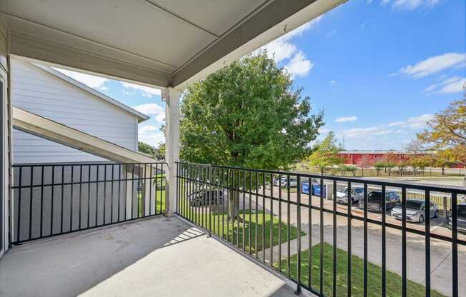 a patio with metal fence and grass