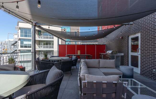 a patio with couches and tables and a red wall