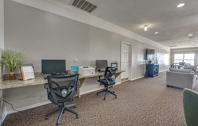 A room with two chairs and a desk with a computer.