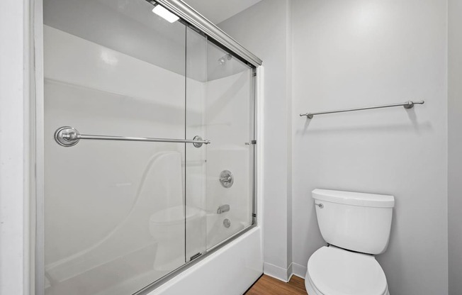 A white toilet in a bathroom with a walk-in shower.