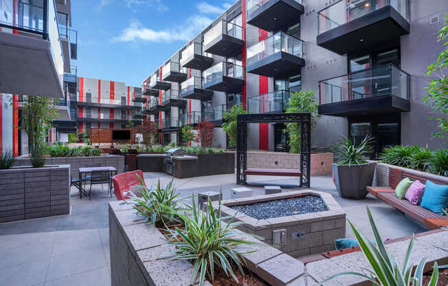 a courtyard with a fire pit in the middle of some apartments