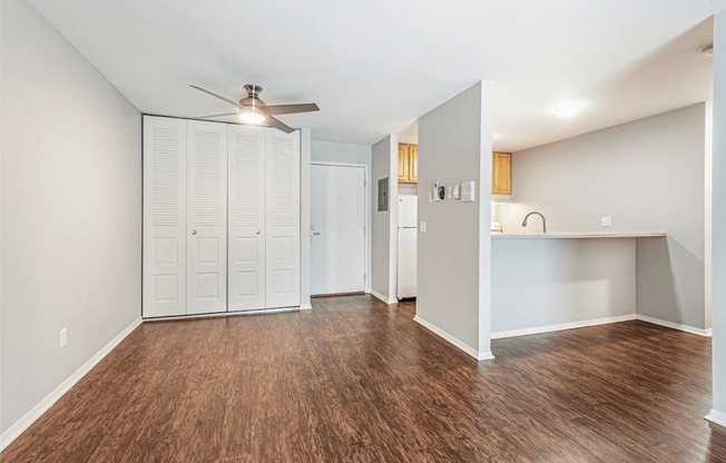 A room with a ceiling fan and wooden flooring.