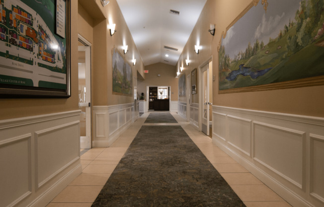 A hallway with a rug and a painting on the wall.