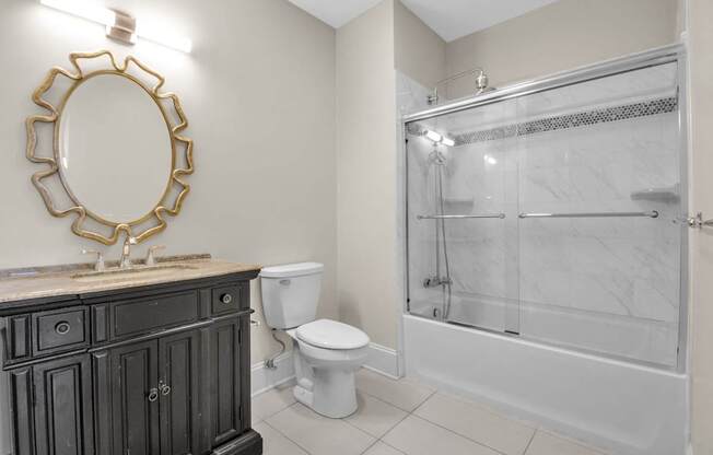 A bathroom with a toilet, sink, and shower at The Knights @ 506 Delaware Apartments, Buffalo, New York