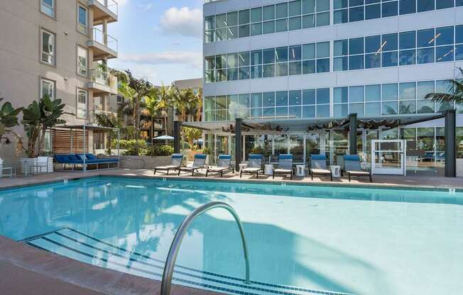 A swimming pool with a metal railing and chairs around it.