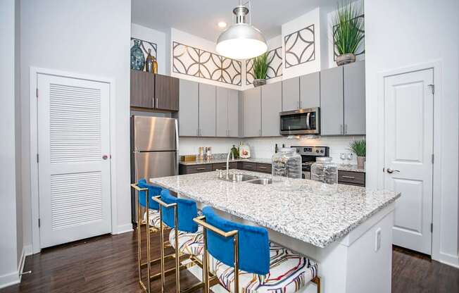 A kitchen with a white countertop and blue barstools.