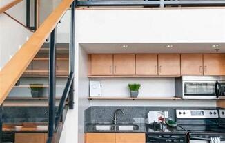 a kitchen with a stainless steel stove and a staircase