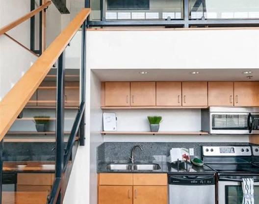 a kitchen with a stainless steel stove and a staircase