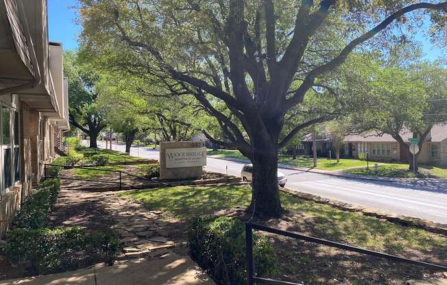 This is a photo of building exteriors and the grounds at Woodbridge Apartments in Dallas, Texas.