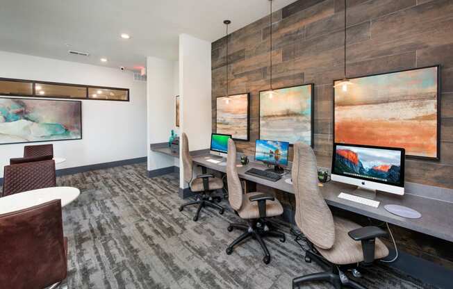 a conference room with three computer desks and chairs