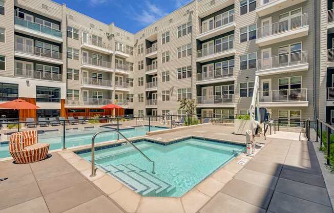 A large swimming pool in front of apartment buildings.