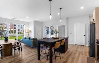 a living room and dining room with a table and chairs