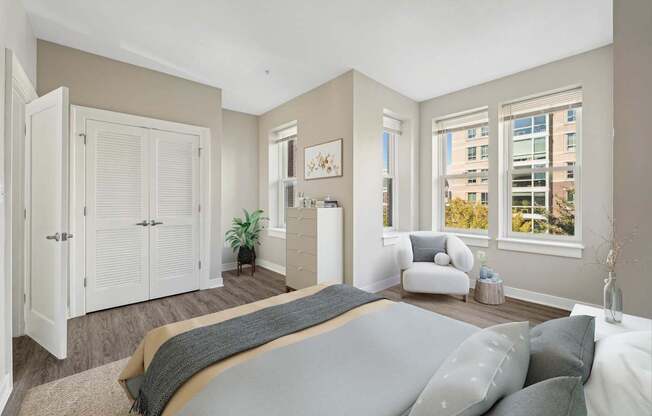 A bedroom with a large bed and a window overlooking a cityscape.