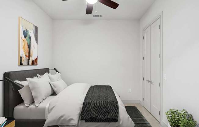 A bedroom with a bed, a ceiling fan, and a painting on the wall.