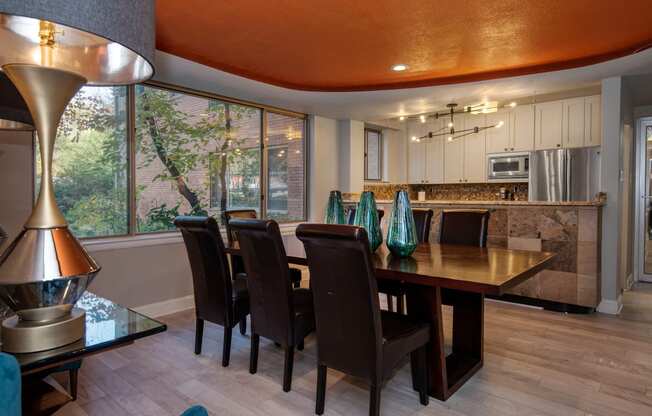 a dining room with an orange ceiling and a long wooden table with black chairs