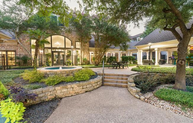 Enjoy peaceful moments or casual conversation in this inviting courtyard, framed by greenery and classic stone architecture.
