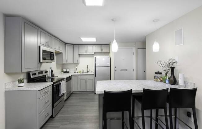 a kitchen with gray cabinets and a white counter top at Willows Court Apartment Homes, Seattle, Washington 98125