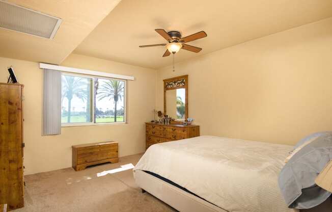 a bedroom with a bed and a ceiling fan