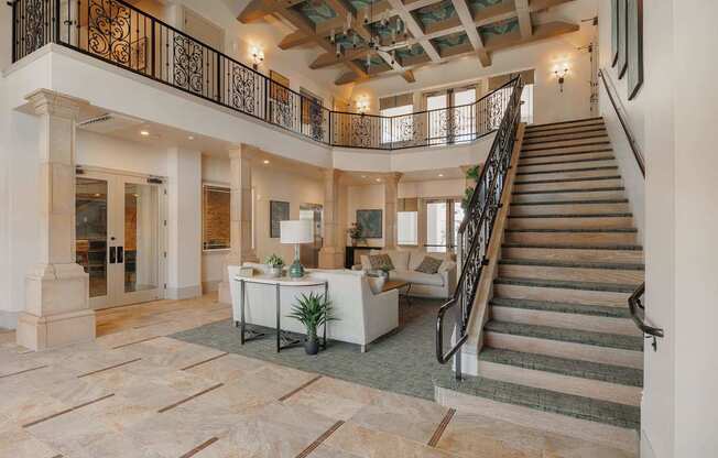 A large open space with a staircase and a table with a plant on it.