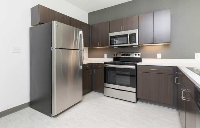 Modern open-concept kitchen and living area with stainless steel appliances.