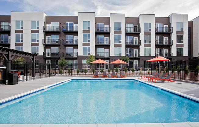 Outdoor pool with lounge seating and umbrellas from a different angle