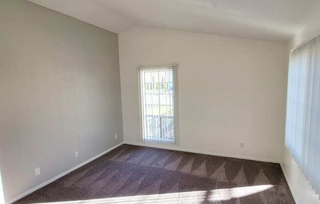 Carpeted living room with lots of natural light in one-bedroom unit at Northwood Apartments in Upland, California.