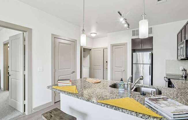 A kitchen with granite countertops and stainless steel appliances at GreenVue Apartments in Richardson, TX