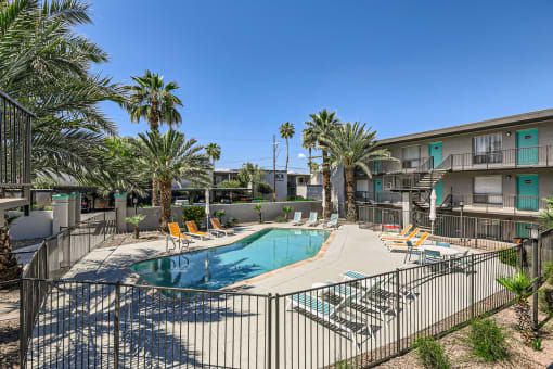 our apartments have a resort style pool with chairs and palm trees