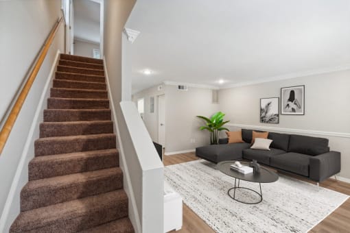 a living room with a staircase and a couch