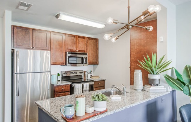 a kitchen with a granite counter top and a stainless steel refrigerator