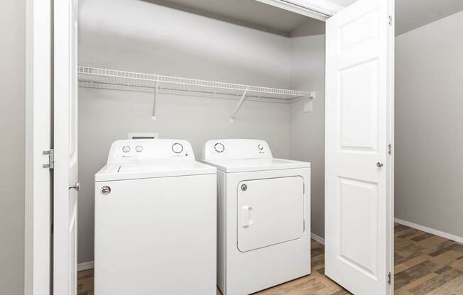 Two white washing machines in a laundry room.